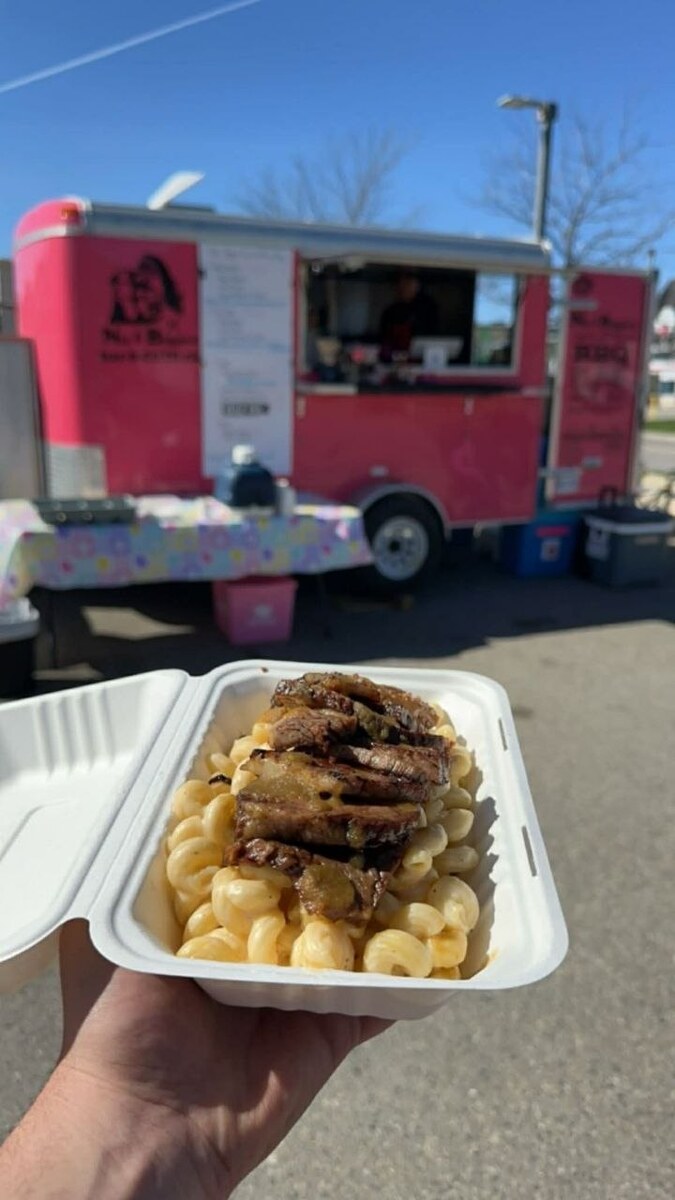 Brisket and mac in front of the pink food truck